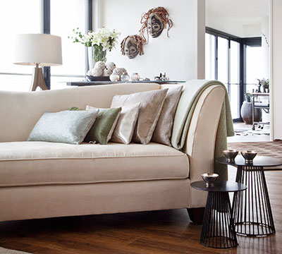 Detail woonkamer Ava met gebriede nohair plaid en sierkussens in leer