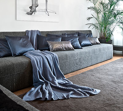 bank met blauwe kussens in denim en zijde